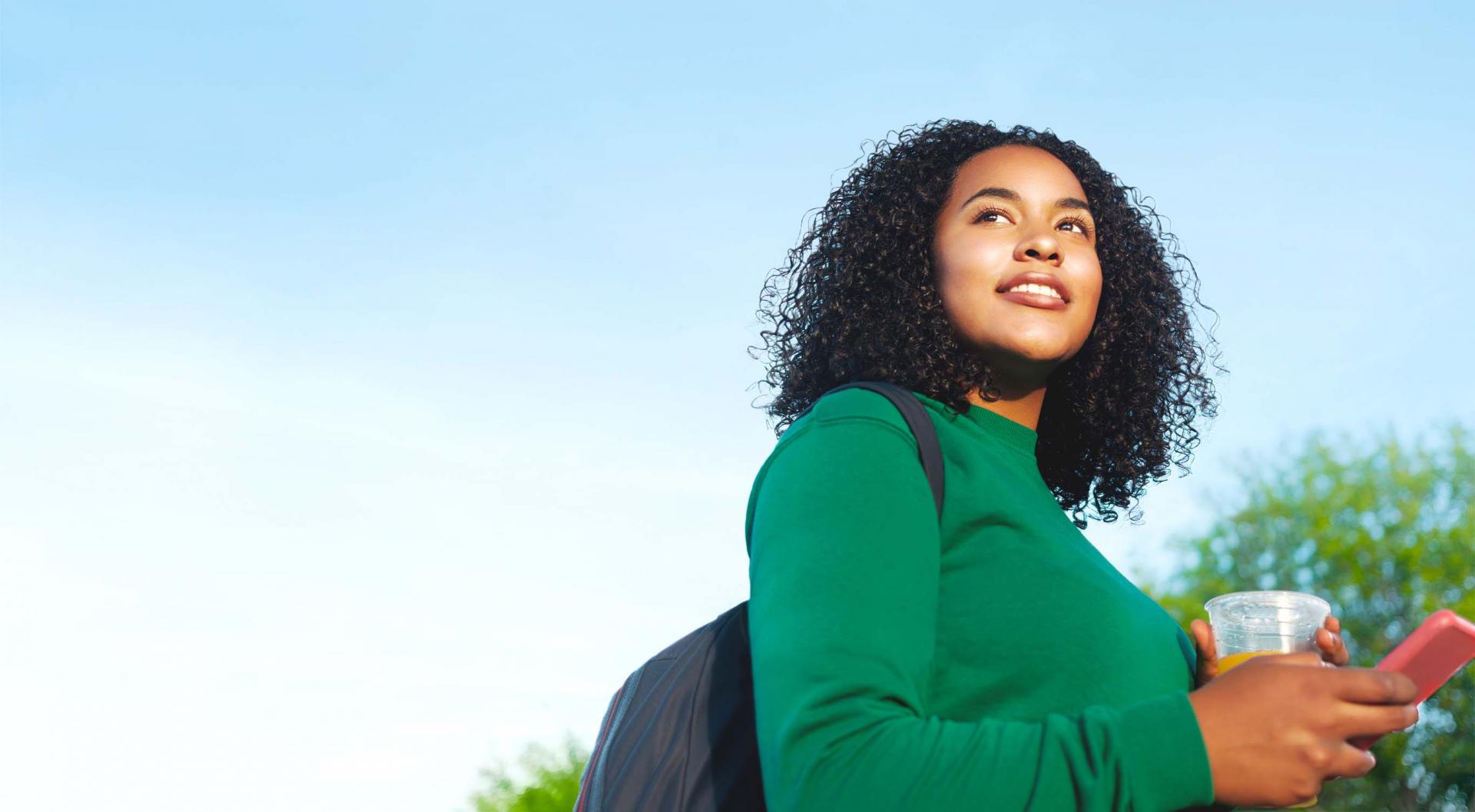 Girl holding a cup with a backpack